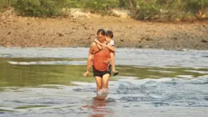 Không có cầu, cha mẹ "nín thở" cõng con vượt sông đến trường