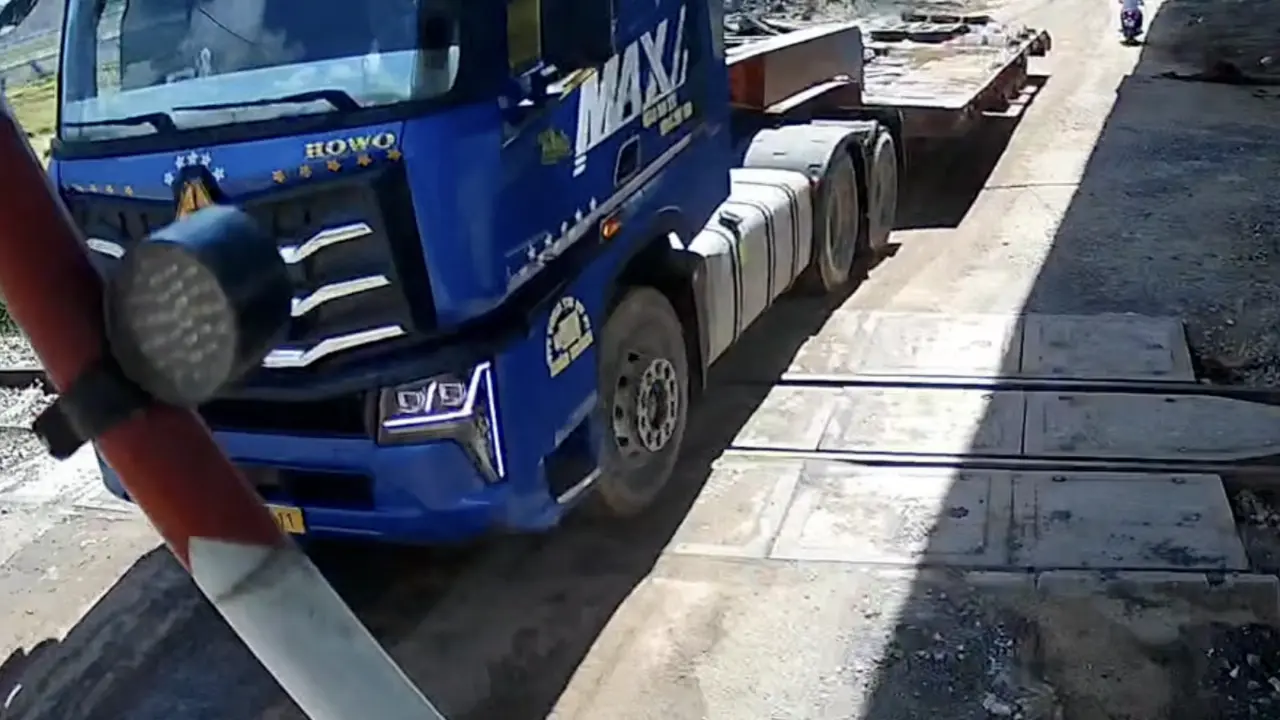 Xe đầu kéo kẹt giữa gác chắn khi tàu sắp đến